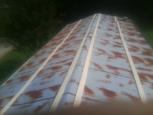 Rusted metal roof panels with new wood purlins before replacement — Storm Damage Roof Repair in Oneco by Roofing Brothers