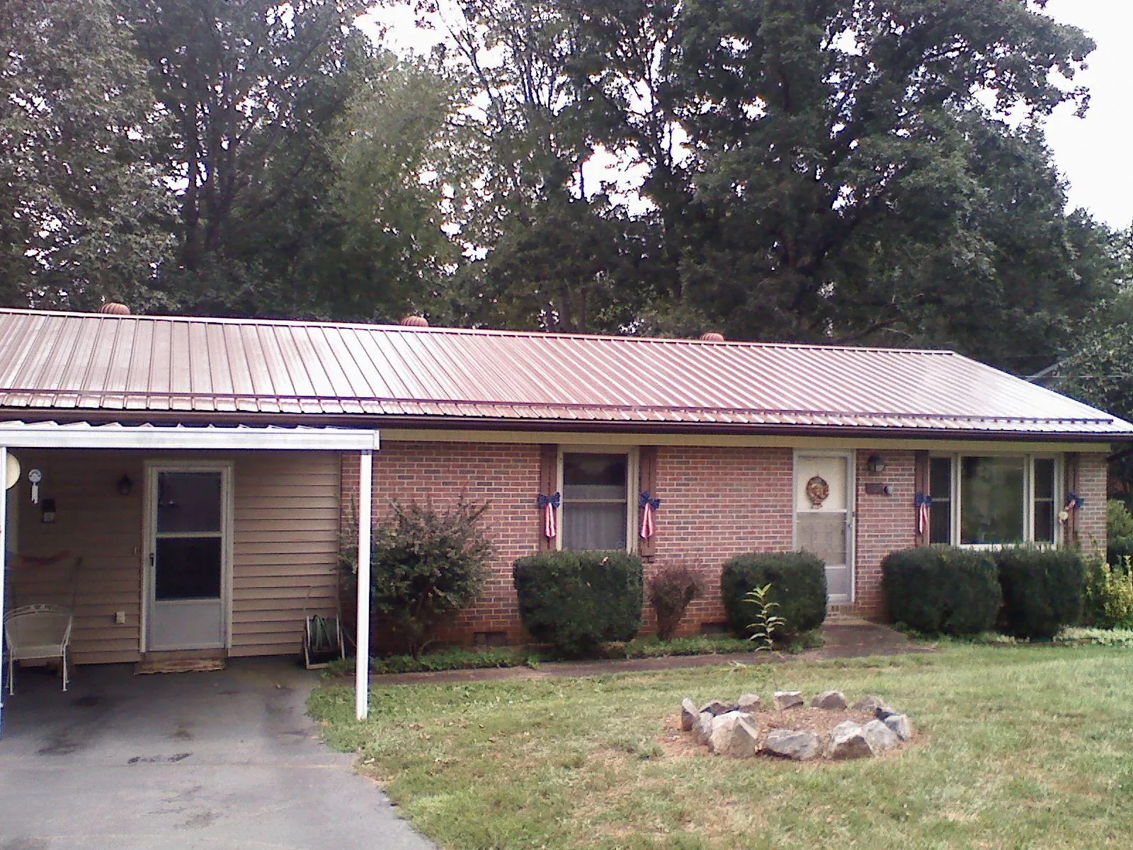 Bronze metal roof and carport on a brick ranch home — Roof Repair work by our crew in Oneco